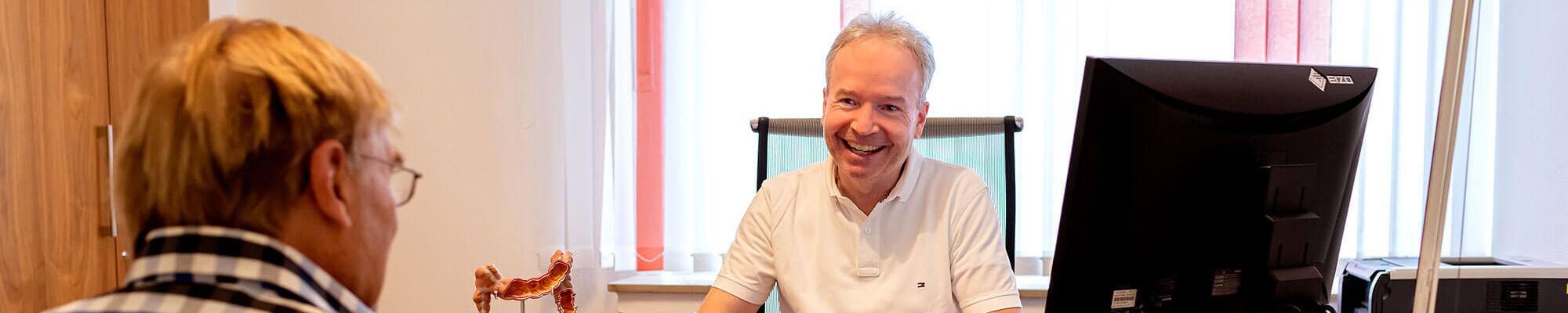 Dr. med. Stefan Rennert im Gespräch mit einem Patienten